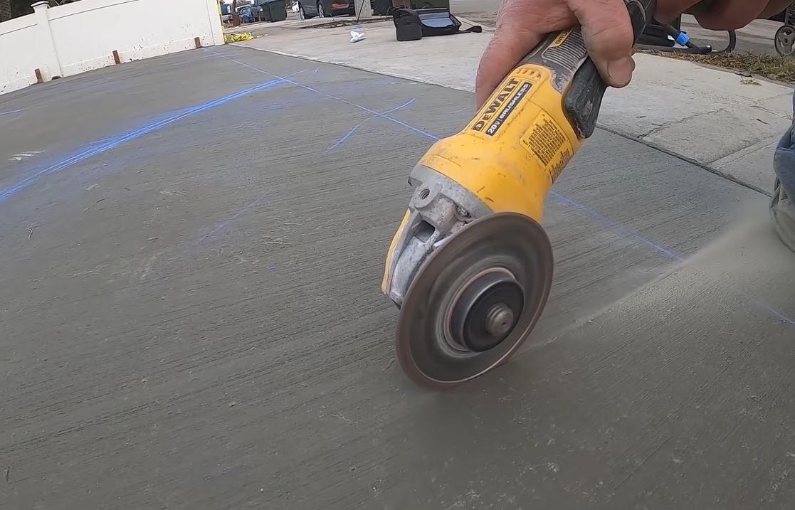 concrete contractor cutting control joints with power angle grinder