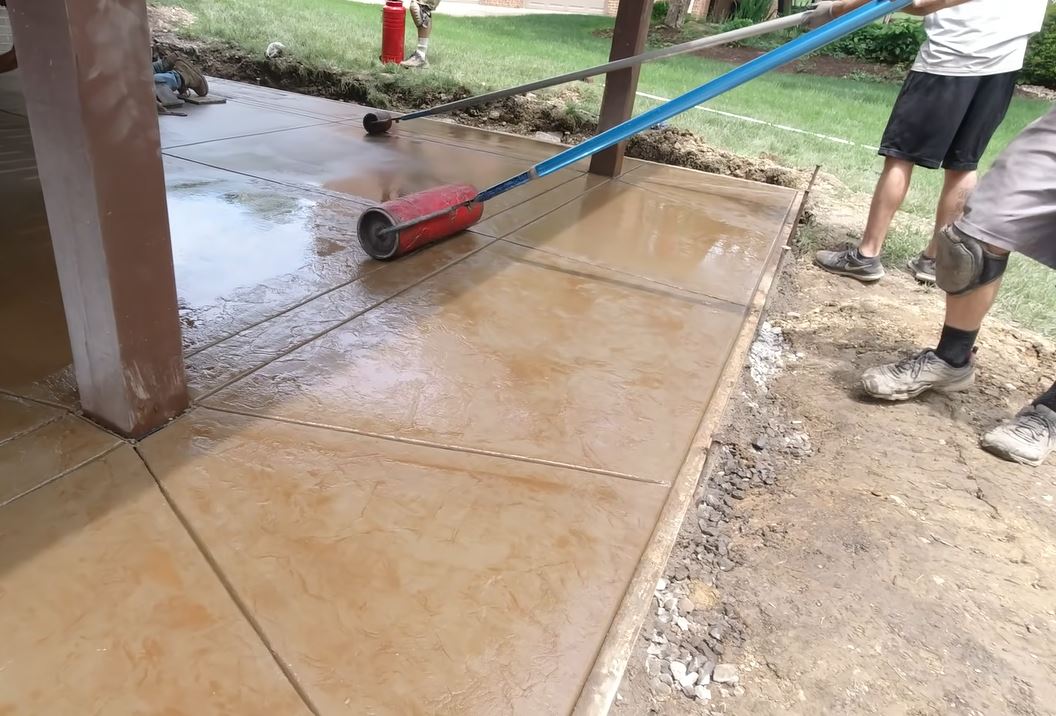 stamped concrete installation using texture roller on wet surface